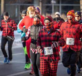 group of people decked out in flannel run in a street