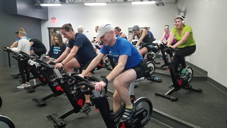 a group of people on spin bikes in a cycle studio